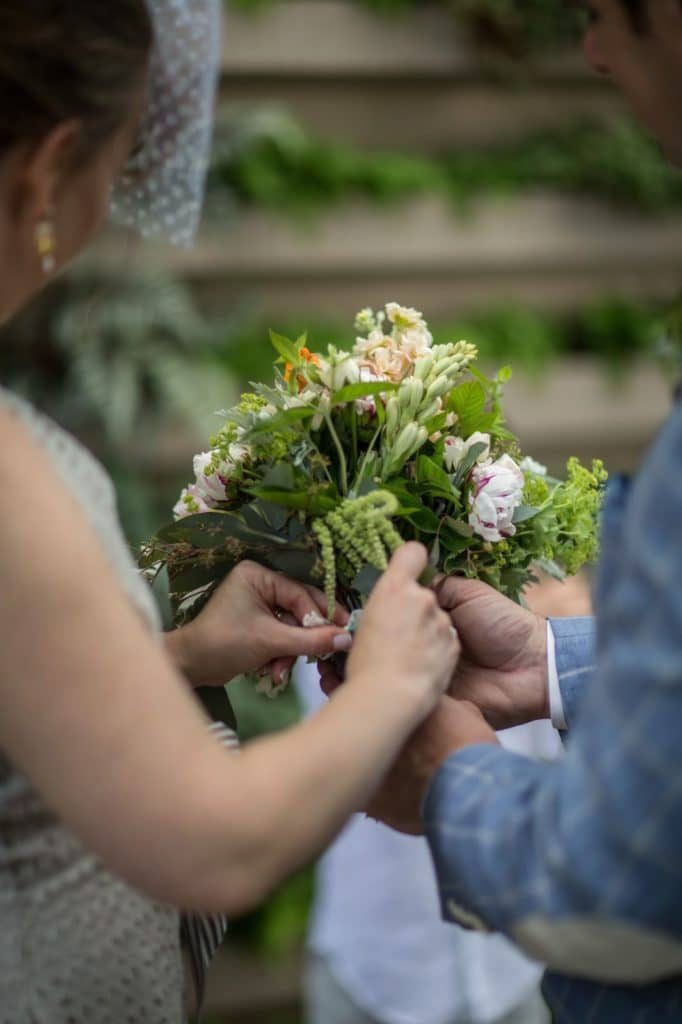 Heather + Nathan, Family Vow Renewal with Kissing on the Lips 15 Tying the mini bouqets together Alisa Tongg Celebrant Family Vow Renewal at The Living Wall at Promise Ridge Jeremie Barlow Photography
